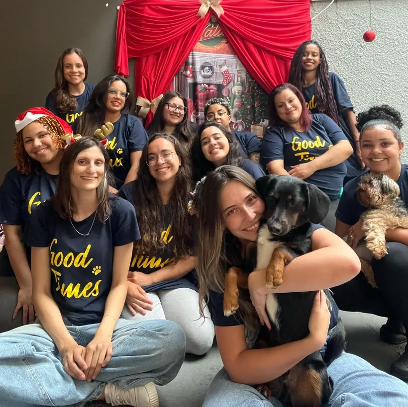 Equipe da Good Times reunida, com uniforme da casa e cães no colo